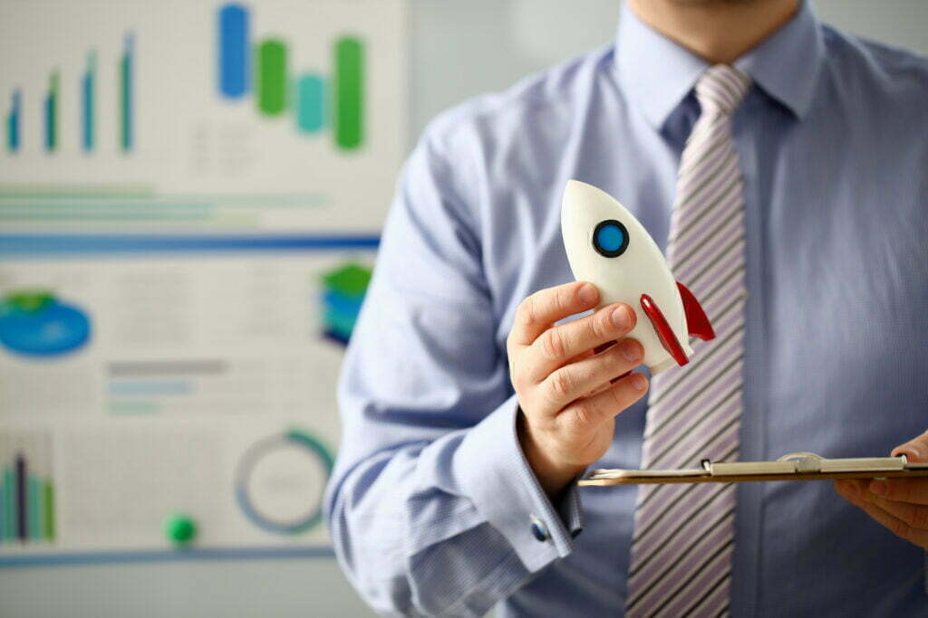 Businessman in suit hold white rockrt in hand